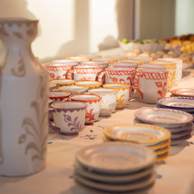Table with ceramic cups and plates featuring floral patterns. - lifestyle