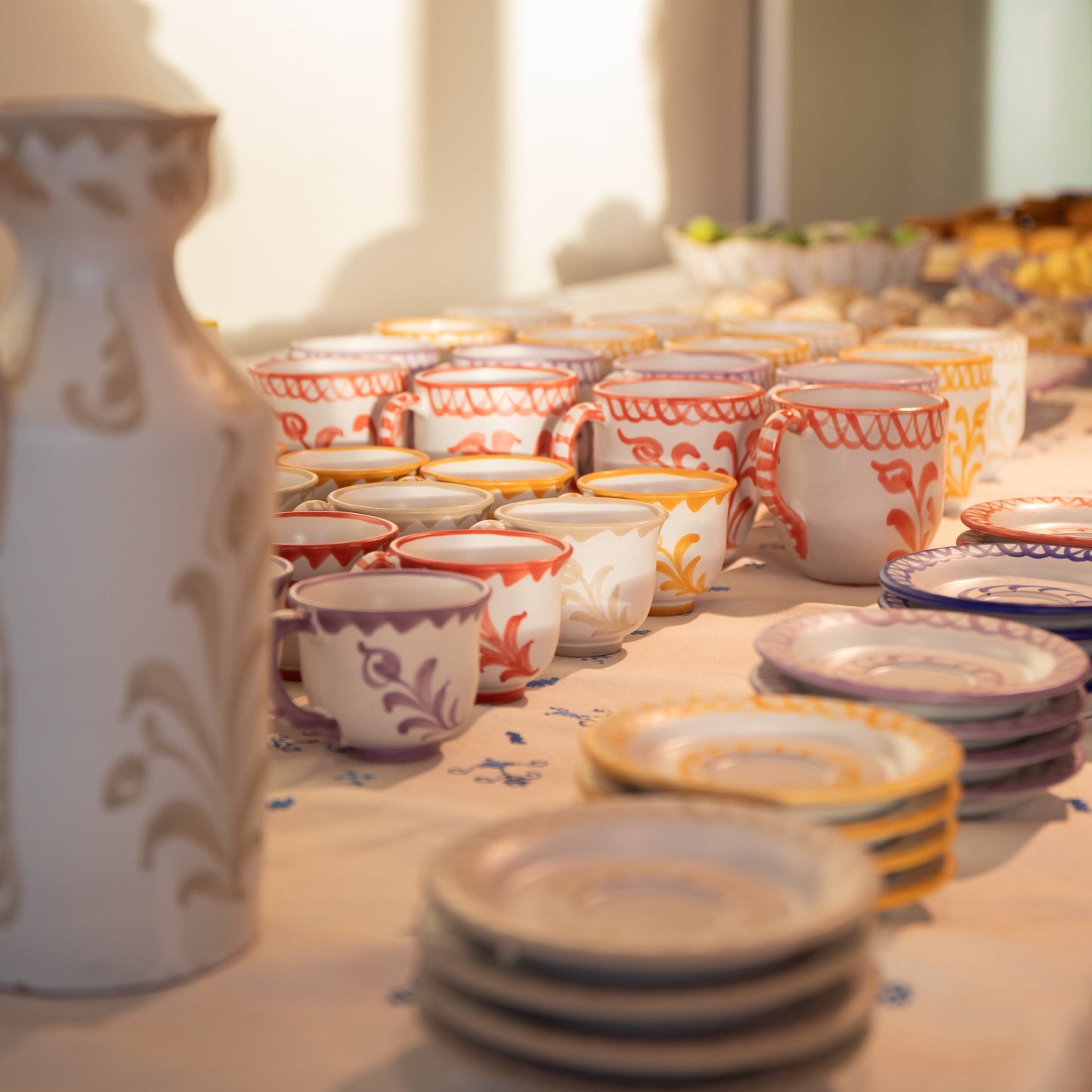 Table with ceramic cups and plates featuring floral patterns. - lifestyle