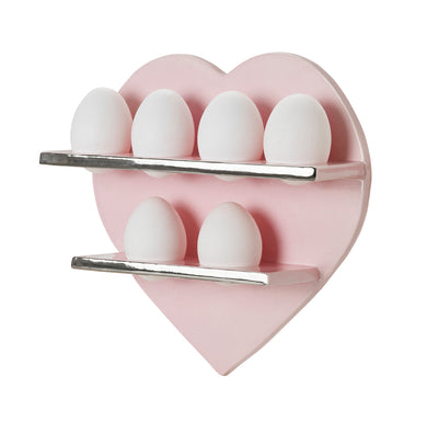 Pink heart-shaped egg holder with chrome silver shelves and white eggs on a white background