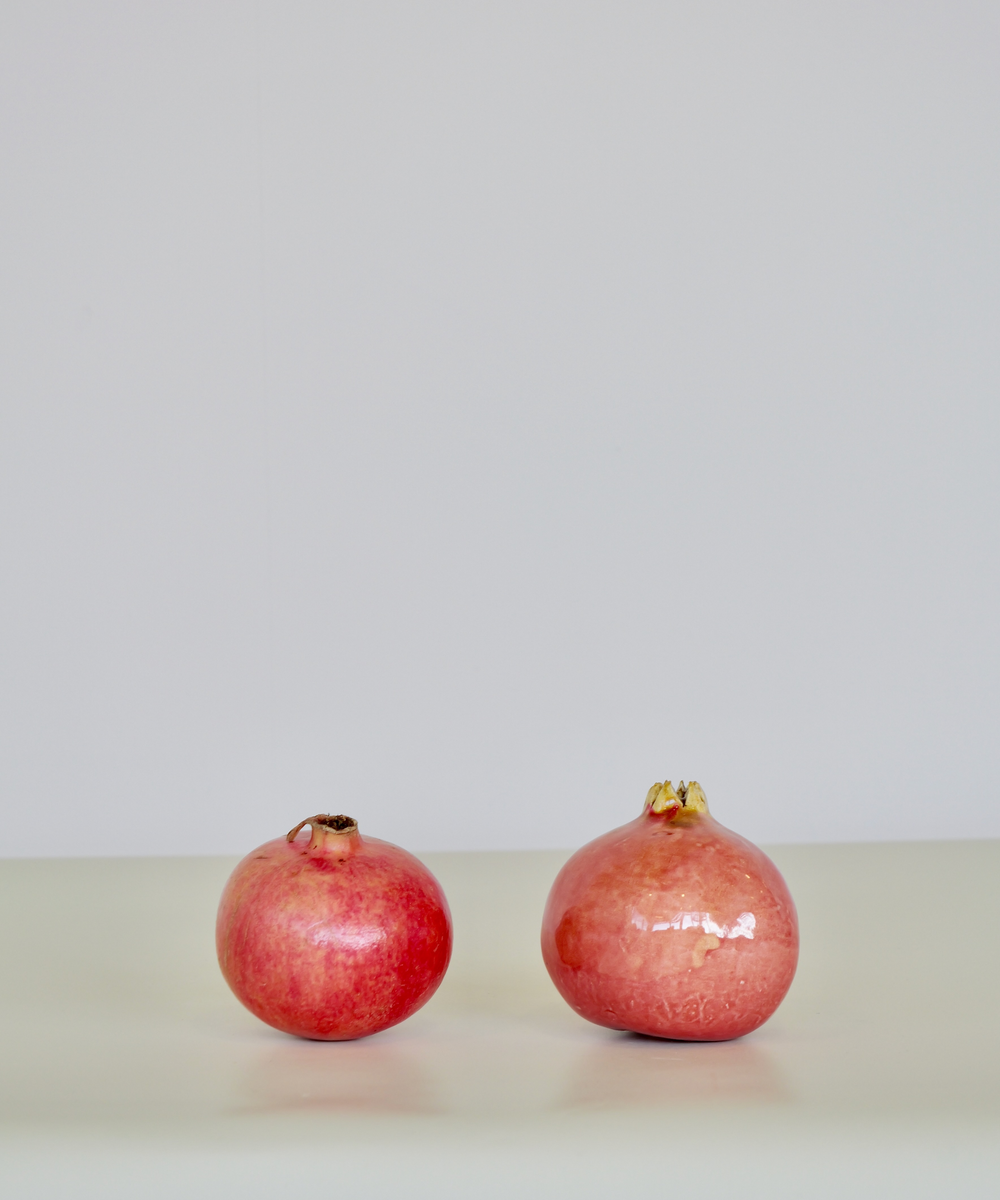 Handcrafted ceramic pomegranate ornament in deep red glaze by Marla Primrose – decorative artisan pottery for home or gift.

