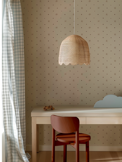 Wooden red children's chair in front of a scandi style desk with a star wallpaper design by Lizzet Frausto and hanging wicker lamp in the background