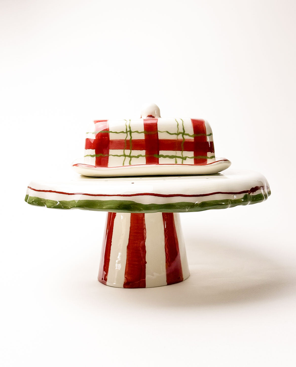 Decorative ceramic cake stand with red and green stripes on a white background