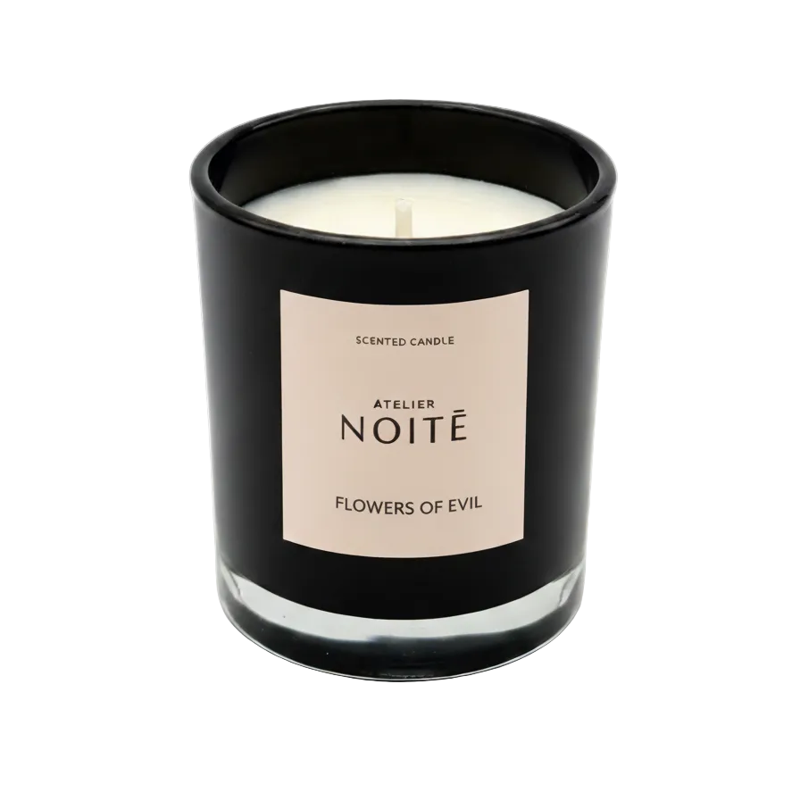 Black candle with a beige label on a white background
