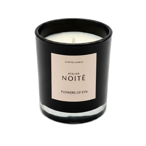 Black candle with a beige label on a white background