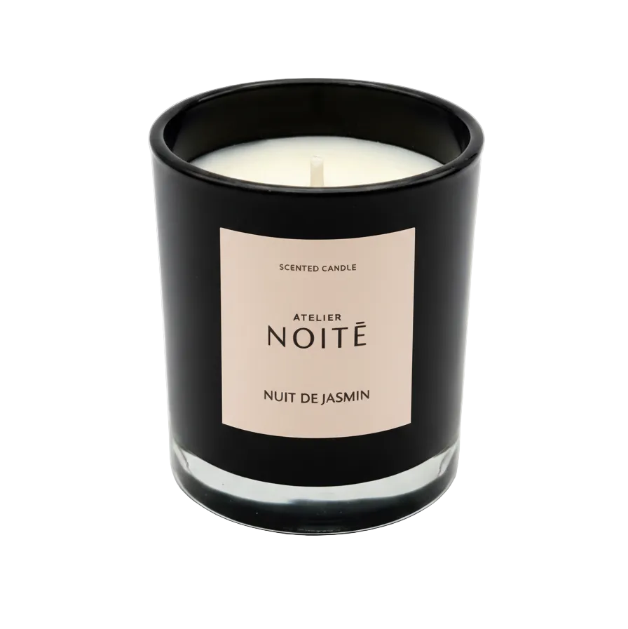 Scented candle in a black container with a beige label on a white background
