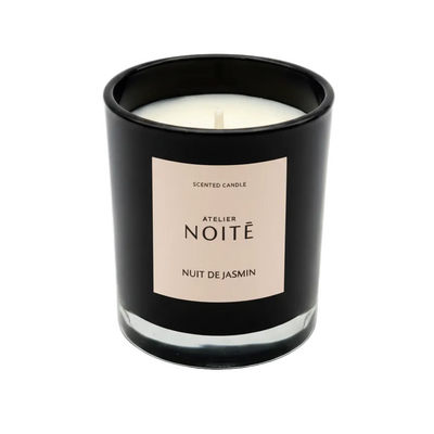 Scented candle in a black container with a beige label on a white background