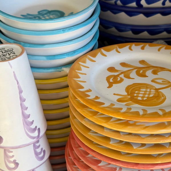 Stacks of colorful ceramic plates and bowls with decorative patterns. - lifestyle