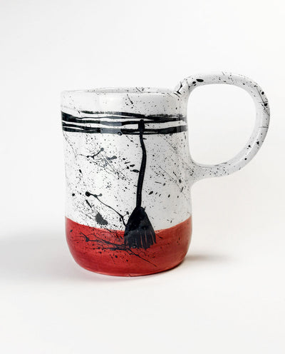 Greek Ceramic carafe with black abstract design and red base on a white background