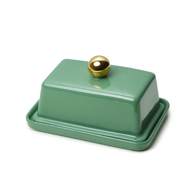 A green ceramic butter dish with a gold-colored knob on the lid.