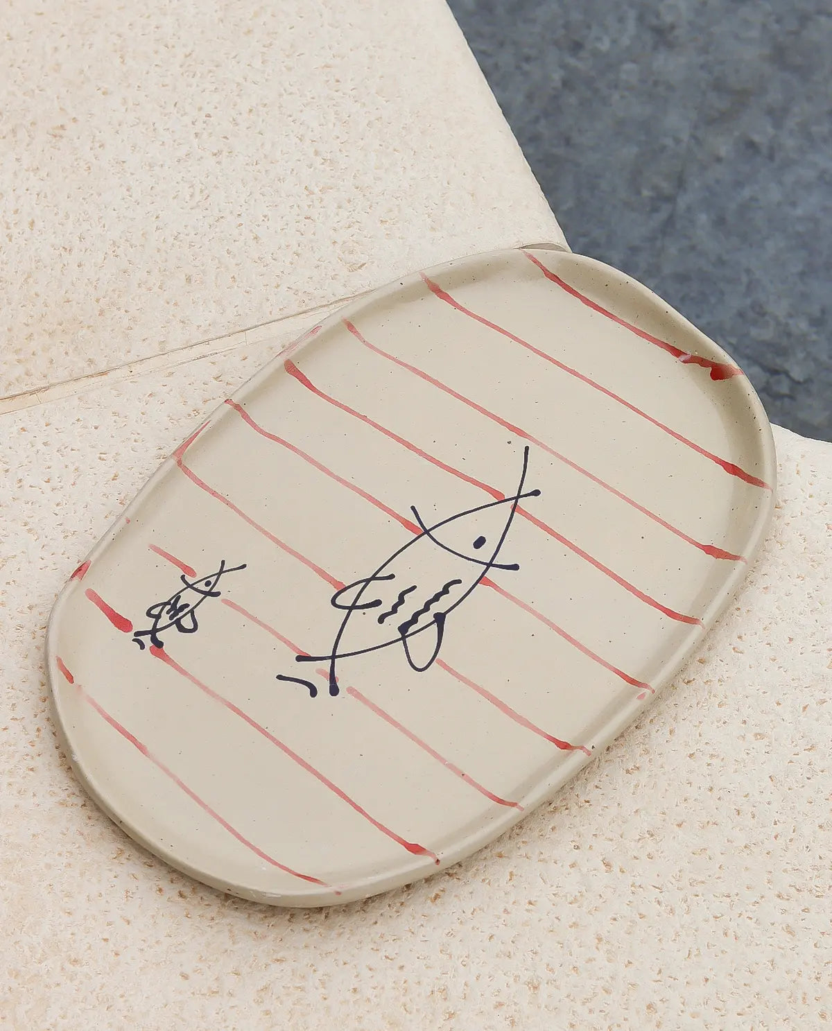 HANDCRAFTED OVAL CERAMIC PLATE WITH RED LINES AND MINIMAL FISH DRAWING