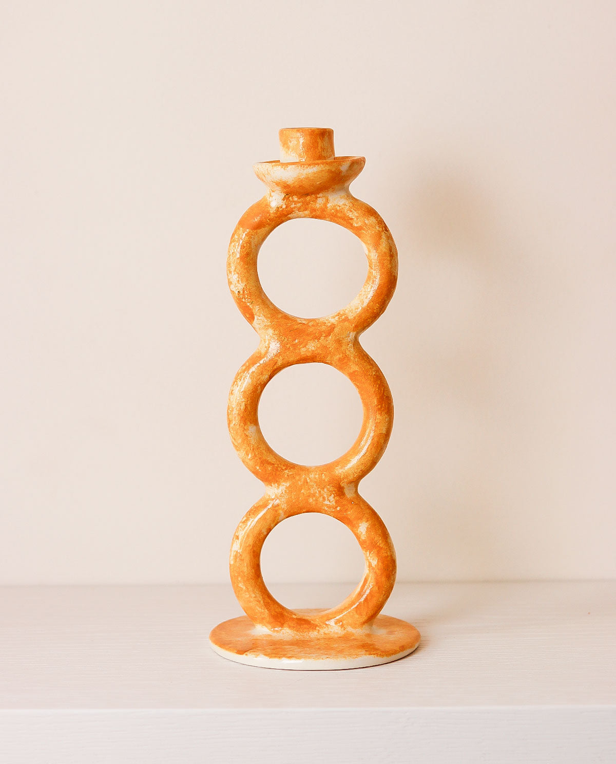 Decorative candle holder with circular design on a plain background