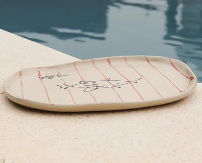 HANDCRAFTED OVAL CERAMIC PLATE WITH RED LINES AND MINIMAL FISH DRAWING