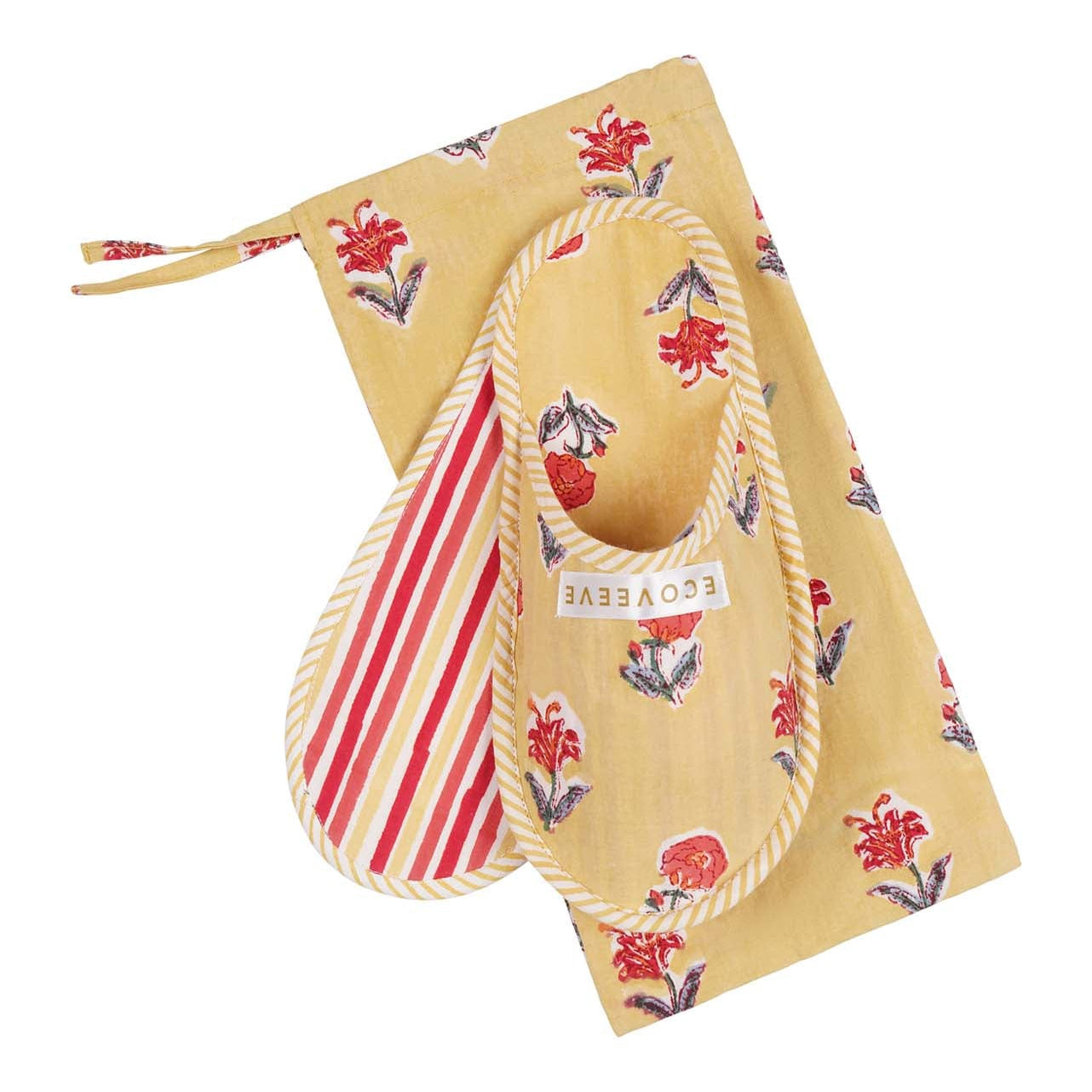 A pair of yellow floral print hand block-printed cotton slippers with red straps, placed on a matching yellow and floral printed fabric.