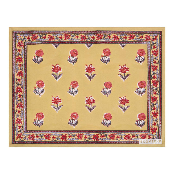 A hand-block printed yellow cotton table mat with red floral patterns and blue border.