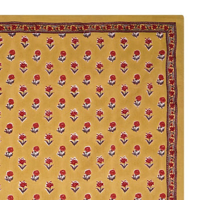 A rectangular tablecloth with a golden yellow base and small floral motifs, with a decorative border.