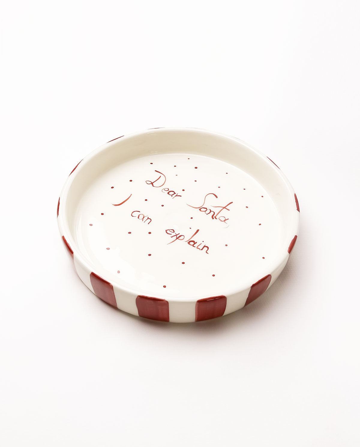 Small ceramic plate with red text on a white background