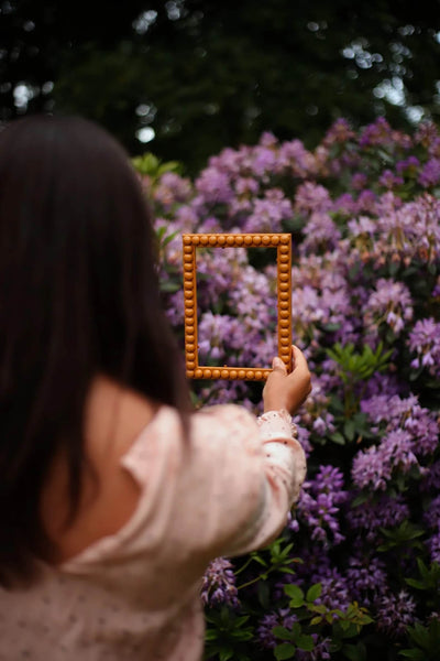 Hand holding Mustard Bobbin Frame