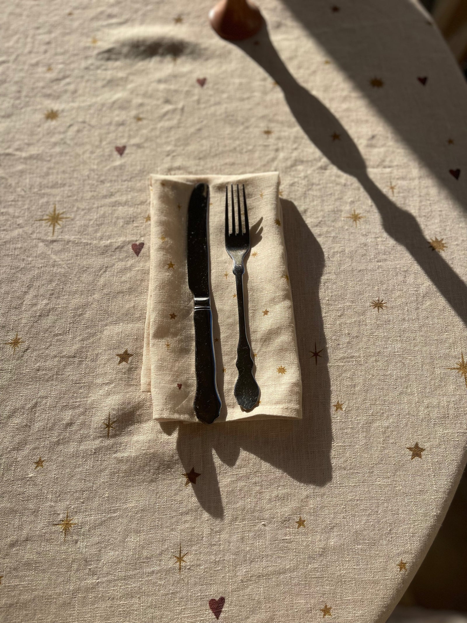 Beautiful celestial dinner napkin set on matching tablecloth with stars and hearts