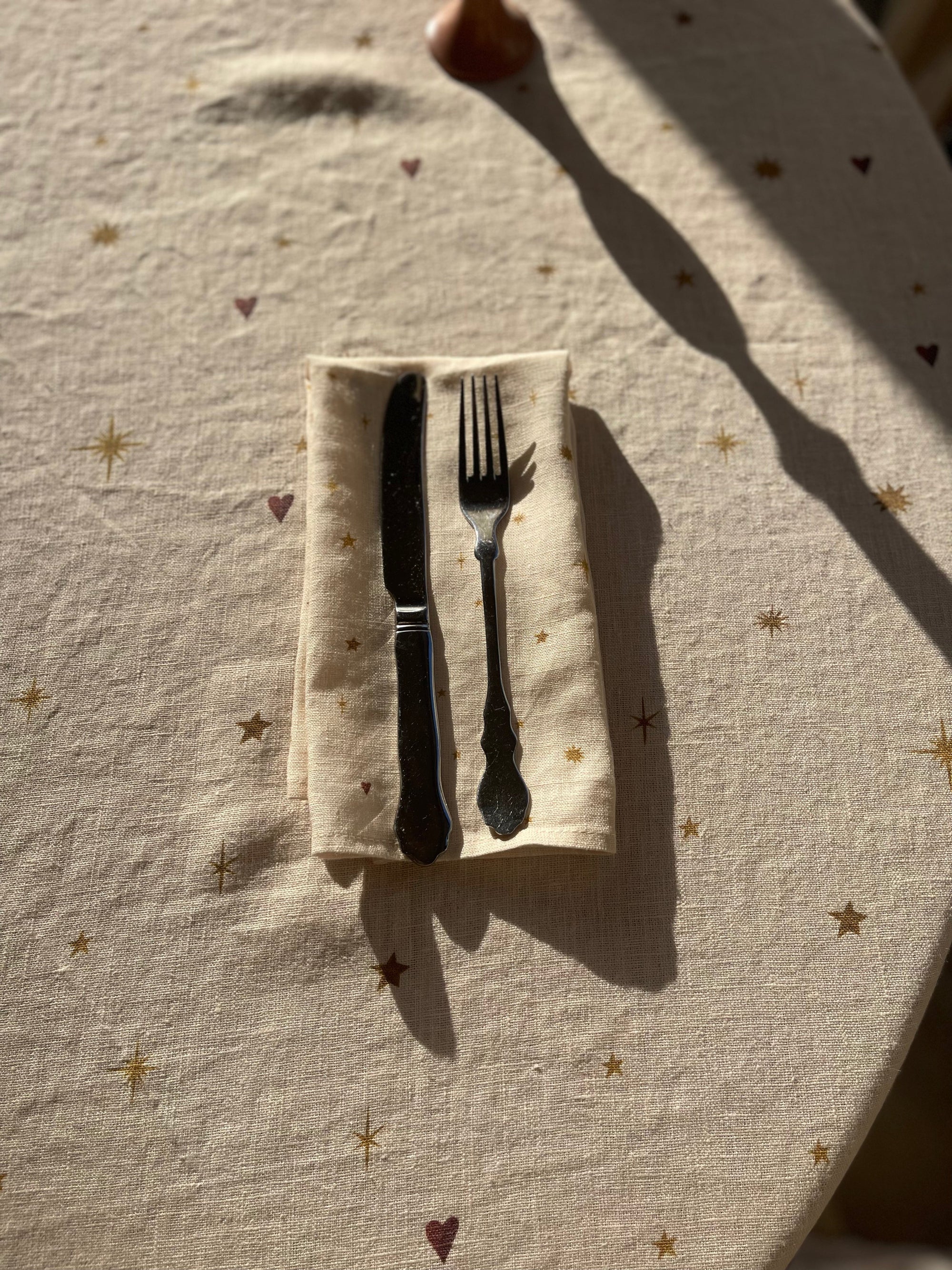 Beautiful celestial dinner napkin set on matching tablecloth with stars and hearts