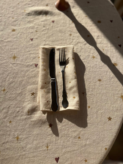 Beautiful celestial dinner napkin set on matching tablecloth with stars and hearts