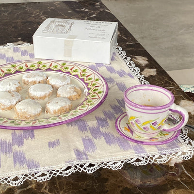 Teacup with cookies on a ceramic  on a tablecloth - lifestyle