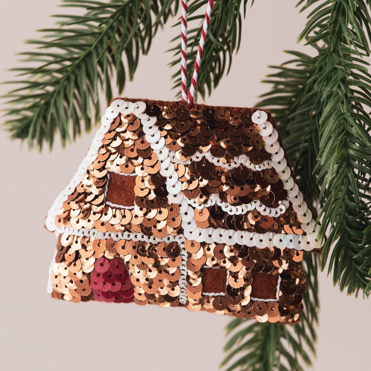 A sequinned gingerbread house ornament