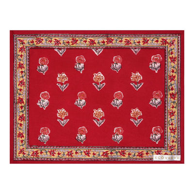 A hand-block printed red cotton table mat with floral patterns and a border.