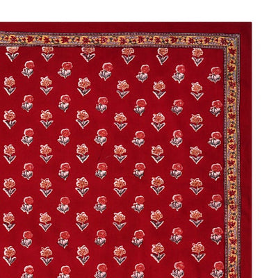A red floral block printed tablecloth with a border