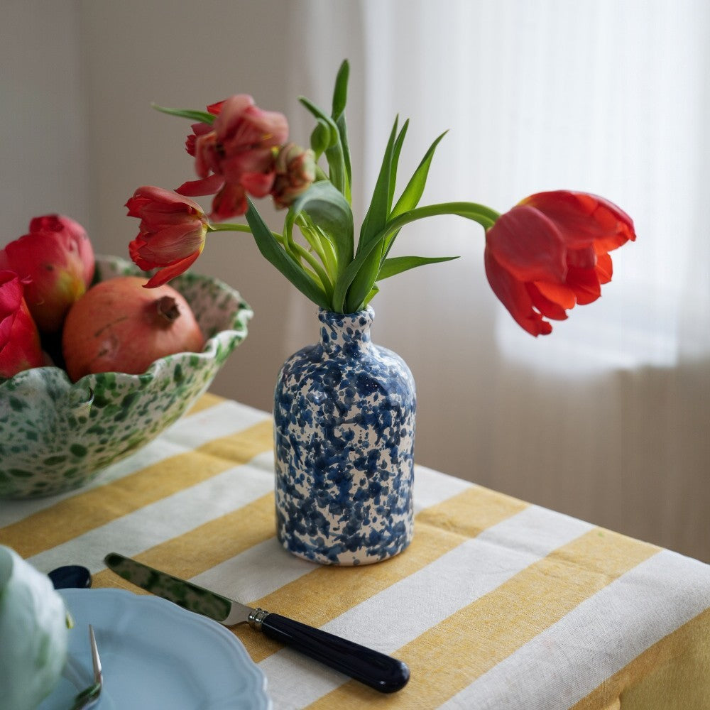 Oil Bottle Blue Moon - Blue and white speckled vase with red tulips on a yellow and white striped tablecloth. - LAMP LDN LIVING