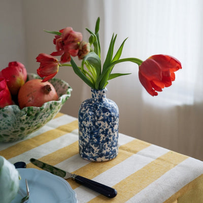 Oil Bottle Blue Moon - Blue and white speckled vase with red tulips on a yellow and white striped tablecloth. - LAMP LDN LIVING