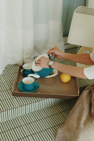 Sand and Cherry dual-tone lacquered tray styled with teal teapot and teacup on tiled step