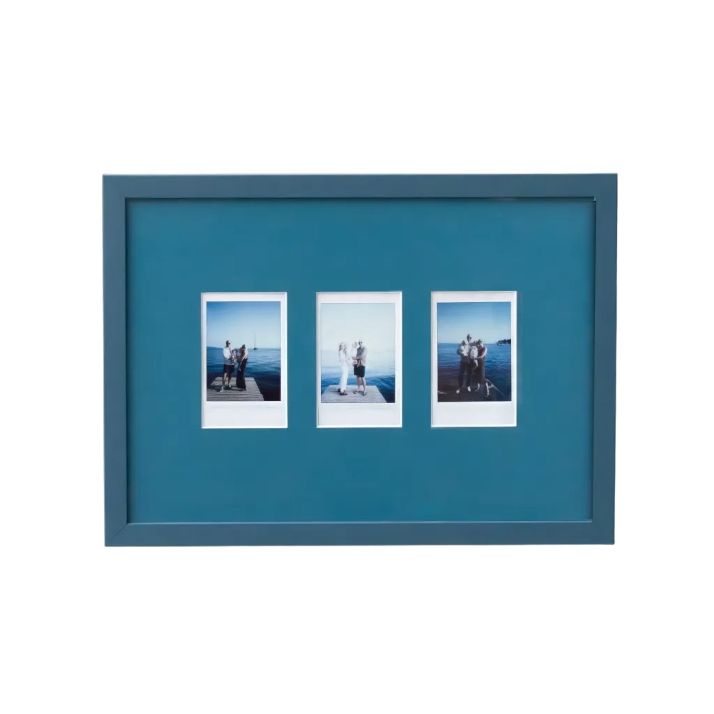 A rectangular Petrol Blue picture frame with three small printed photographs mounted side by side, shown hanging on a plain white wall.