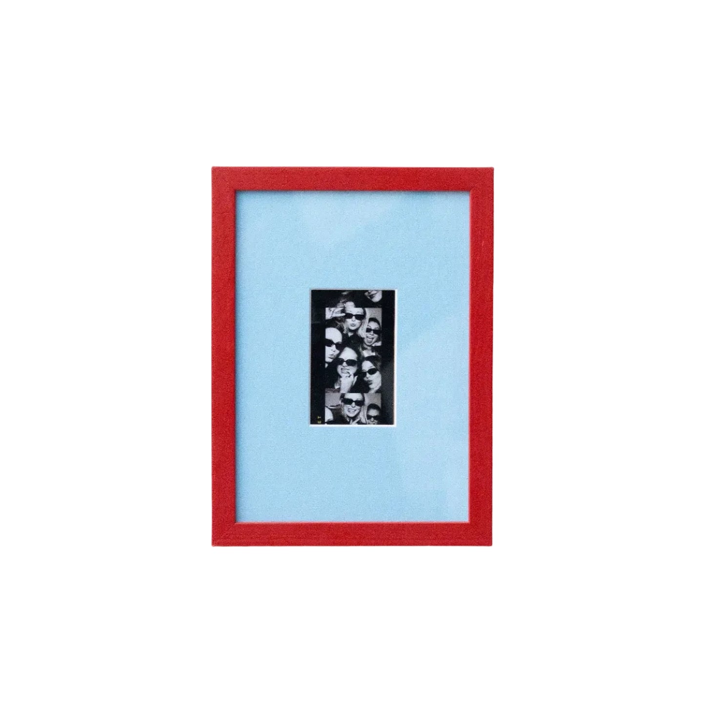 A framed art print featuring a black and white collage in a vertical black frame, set against a light blue mat and a vibrant red outer frame, mounted on a plain white wall.