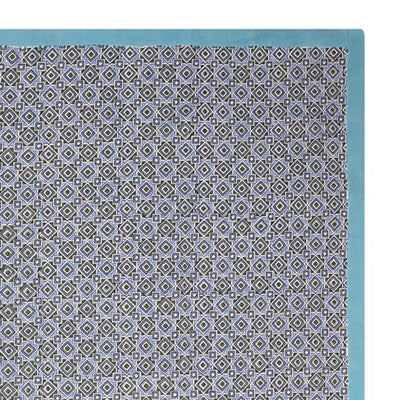 A rectangular tablecloth with a geometric pattern in shades of blue and green, with a solid white border.