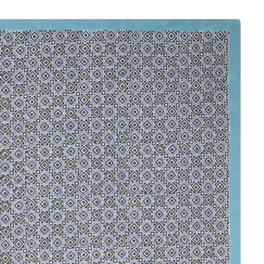 A rectangular tablecloth with a geometric pattern in shades of blue and green, with a solid white border.