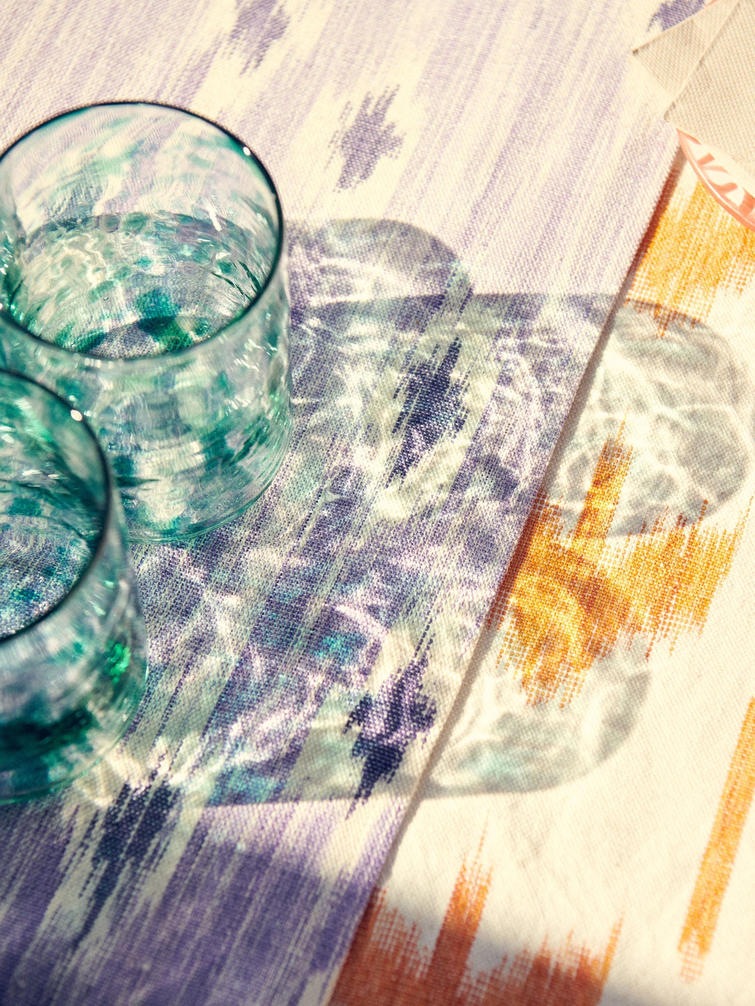 Two glass tumblers on a colorful patterned tablecloth - lifestyle