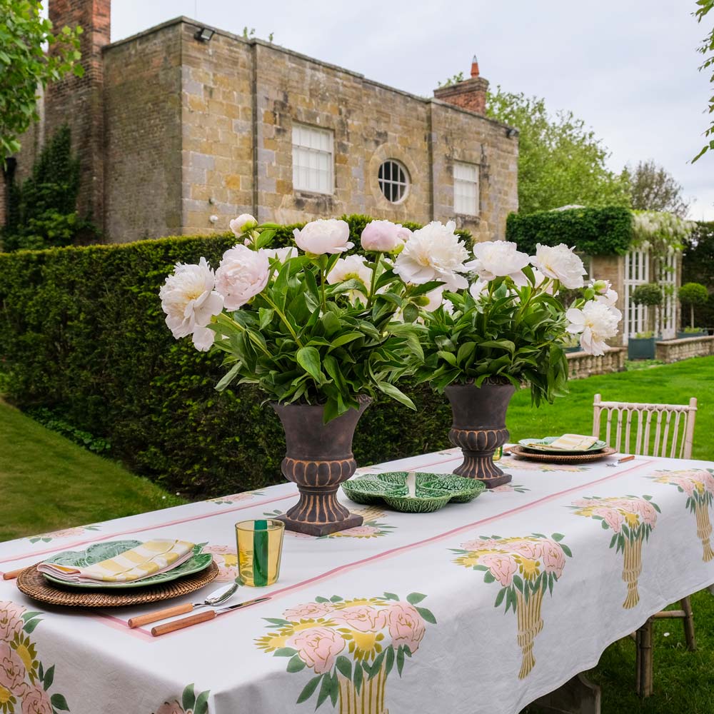 Outdoor table setting with floral centerpiece in a garden