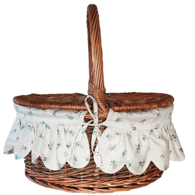 Wicker picnic basket with floral fabric liner on a white background
