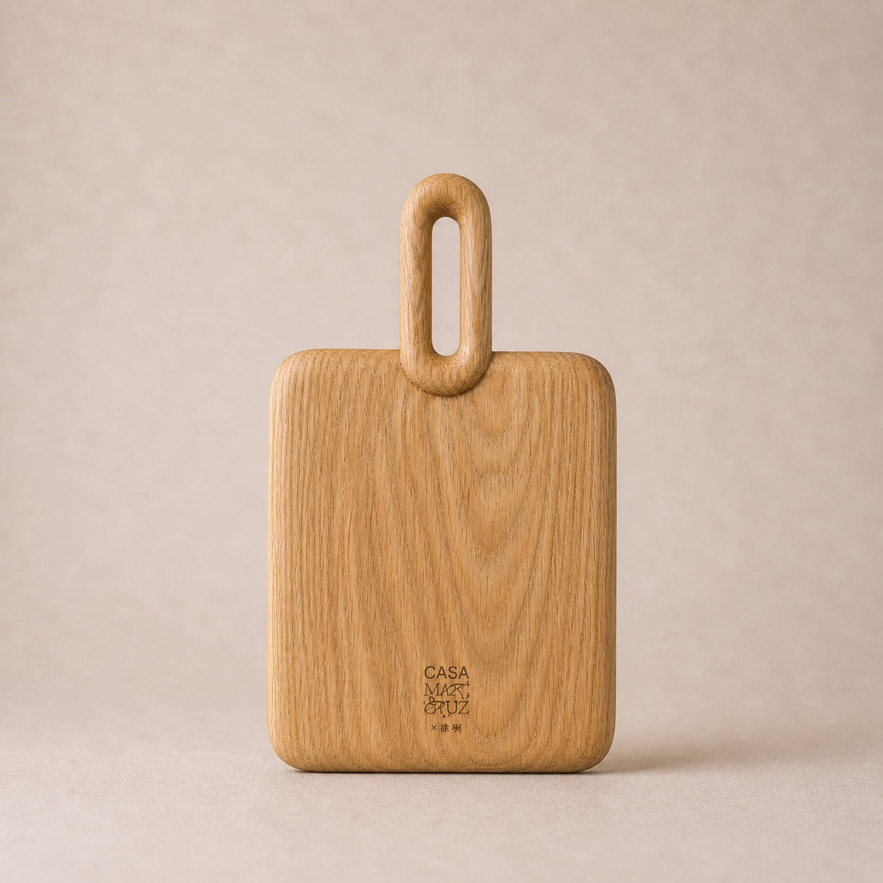 Wooden cutting board with handle on a beige background, featuring the 'Casa' brand.