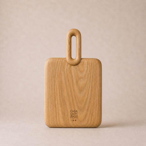Wooden cutting board with handle on a beige background, featuring the 'Casa' brand.