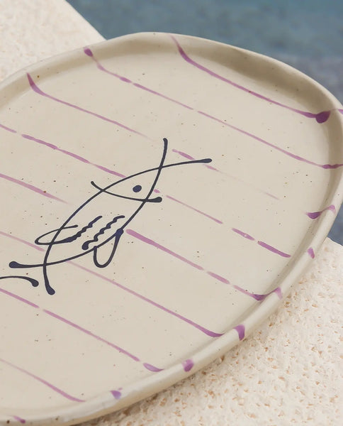 Ceramic plate with purple abstract design on a textured surface