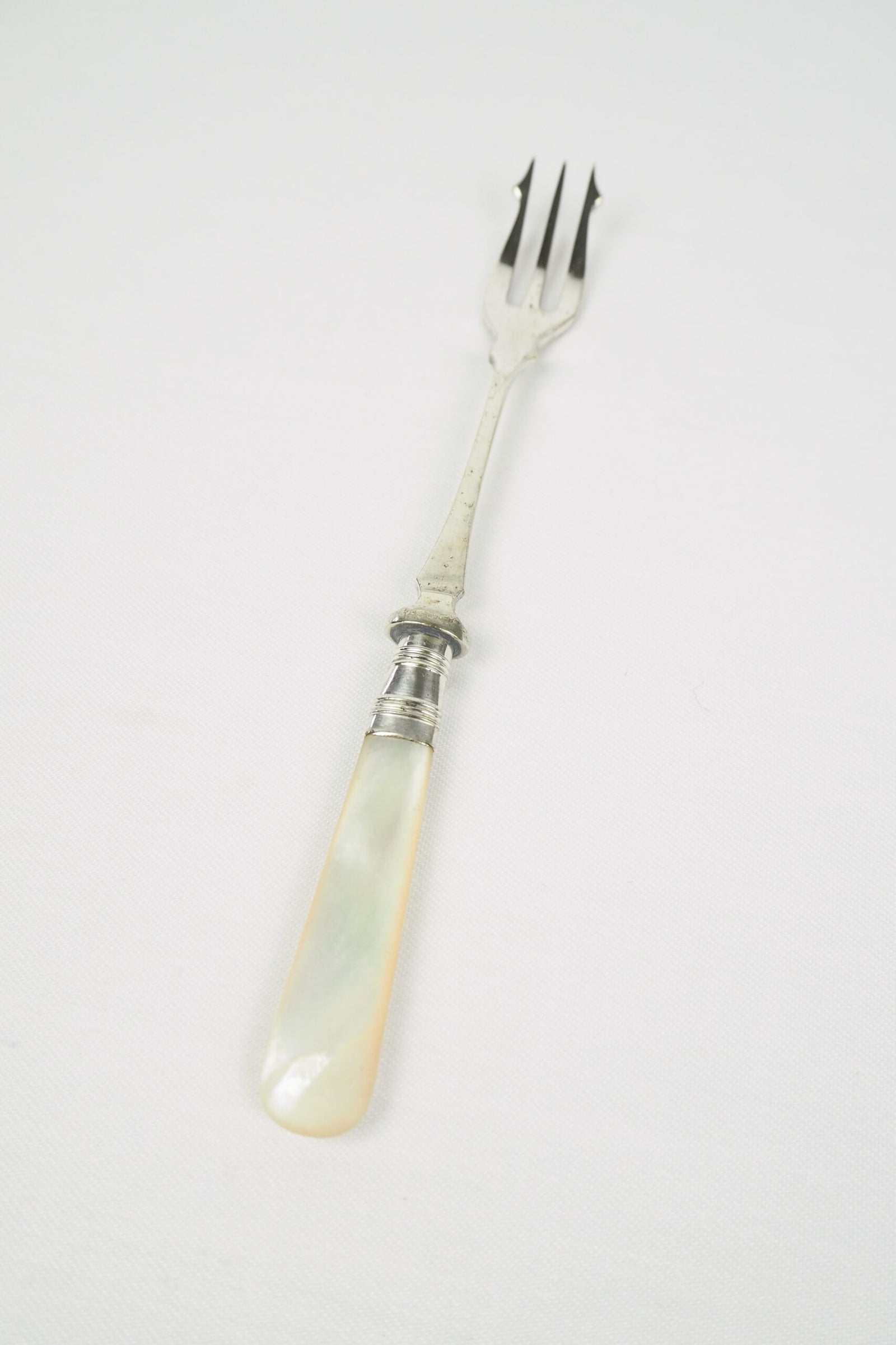 This Antique Pickle Fork is the perfect piece for your kitchen. With a beautiful Mother of Pearl handle and a Silver Plated neck and barbed prongs. Wildmore