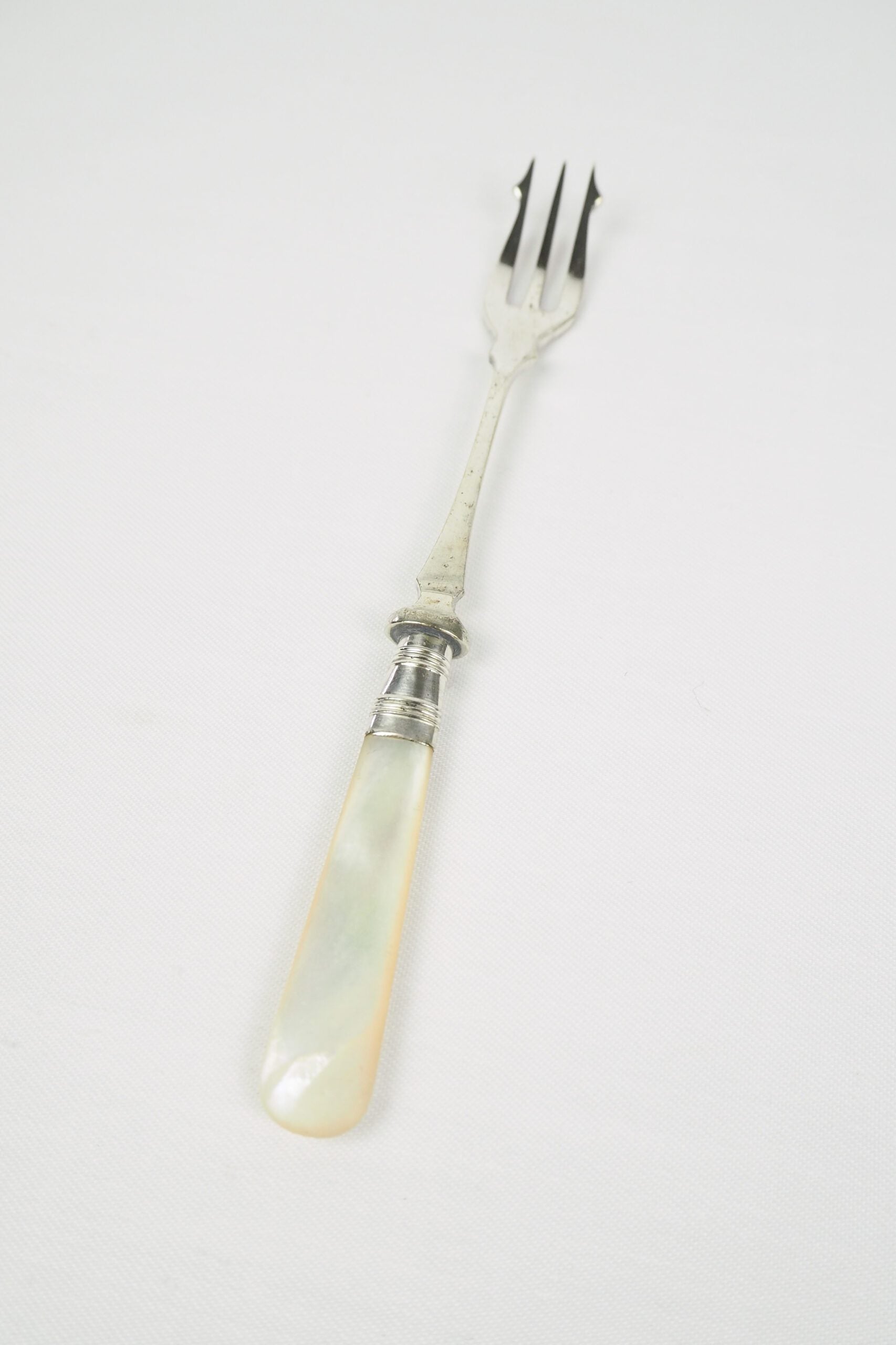 This Antique Pickle Fork is the perfect piece for your kitchen. With a beautiful Mother of Pearl handle and a Silver Plated neck and barbed prongs. Wildmore