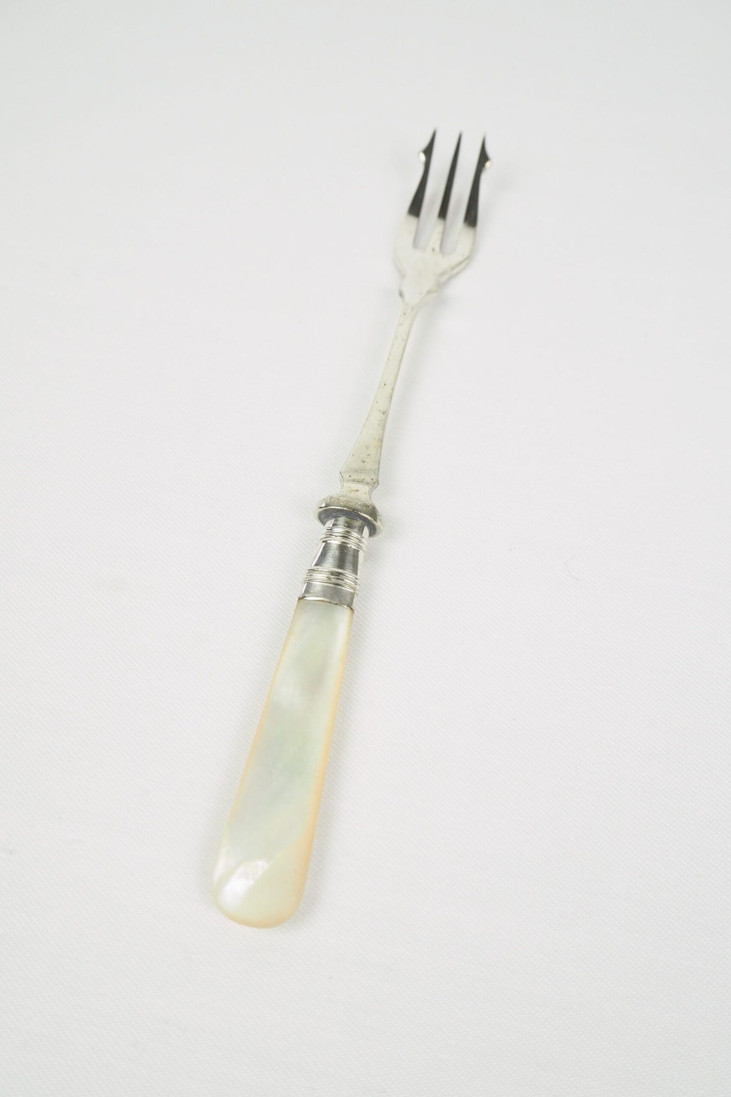 This Antique Pickle Fork is the perfect piece for your kitchen. With a beautiful Mother of Pearl handle and a Silver Plated neck and barbed prongs. Wildmore