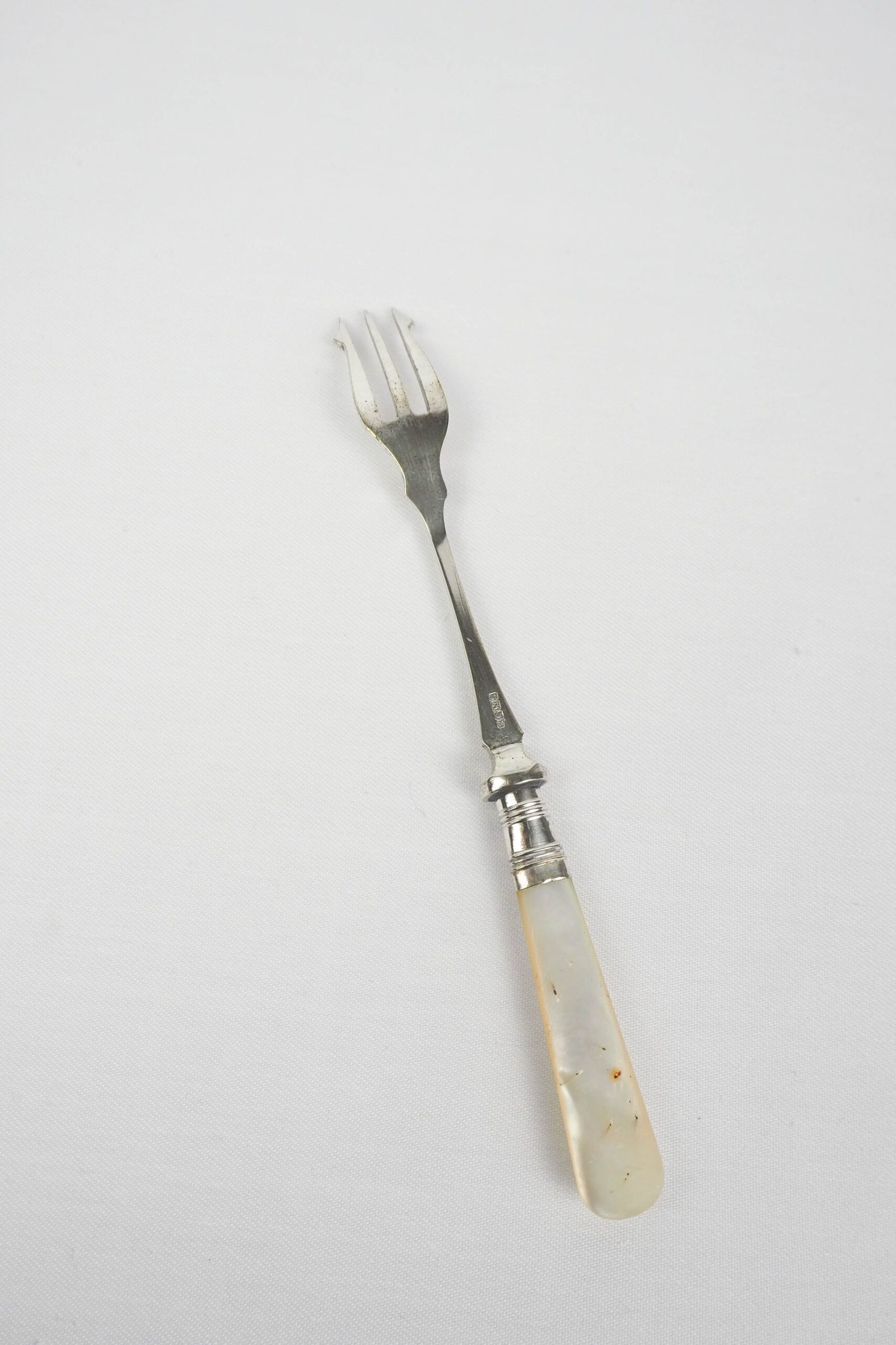 This Antique Pickle Fork is the perfect piece for your kitchen. With a beautiful Mother of Pearl handle and a Silver Plated neck and barbed prongs. Wildmore