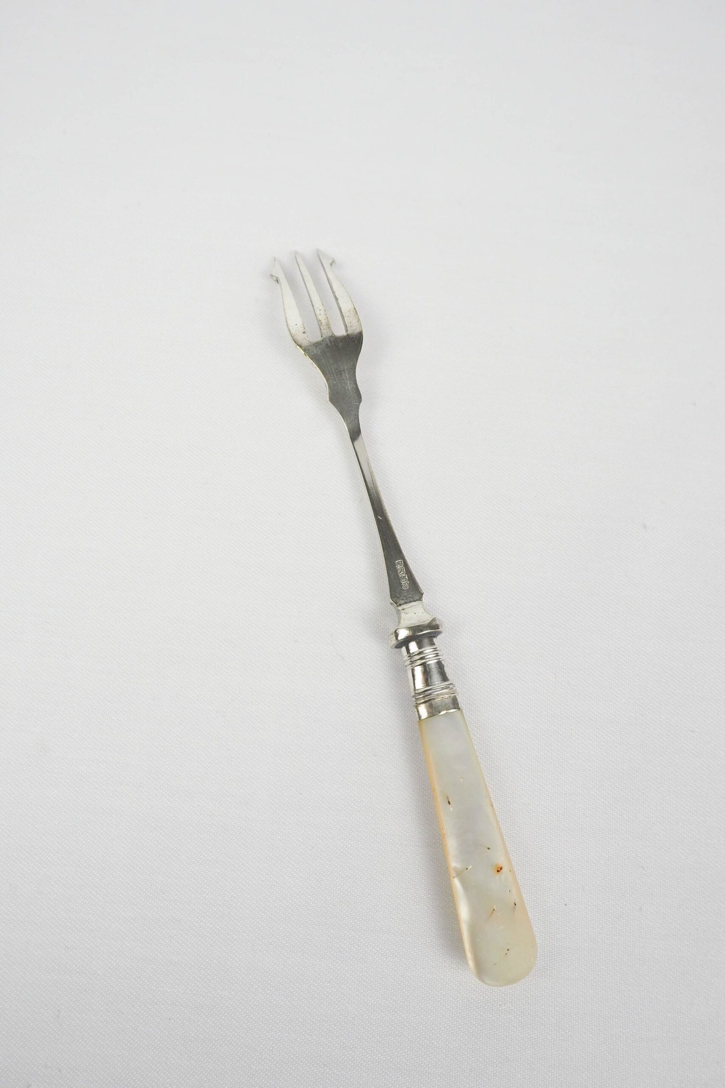 This Antique Pickle Fork is the perfect piece for your kitchen. With a beautiful Mother of Pearl handle and a Silver Plated neck and barbed prongs. Wildmore