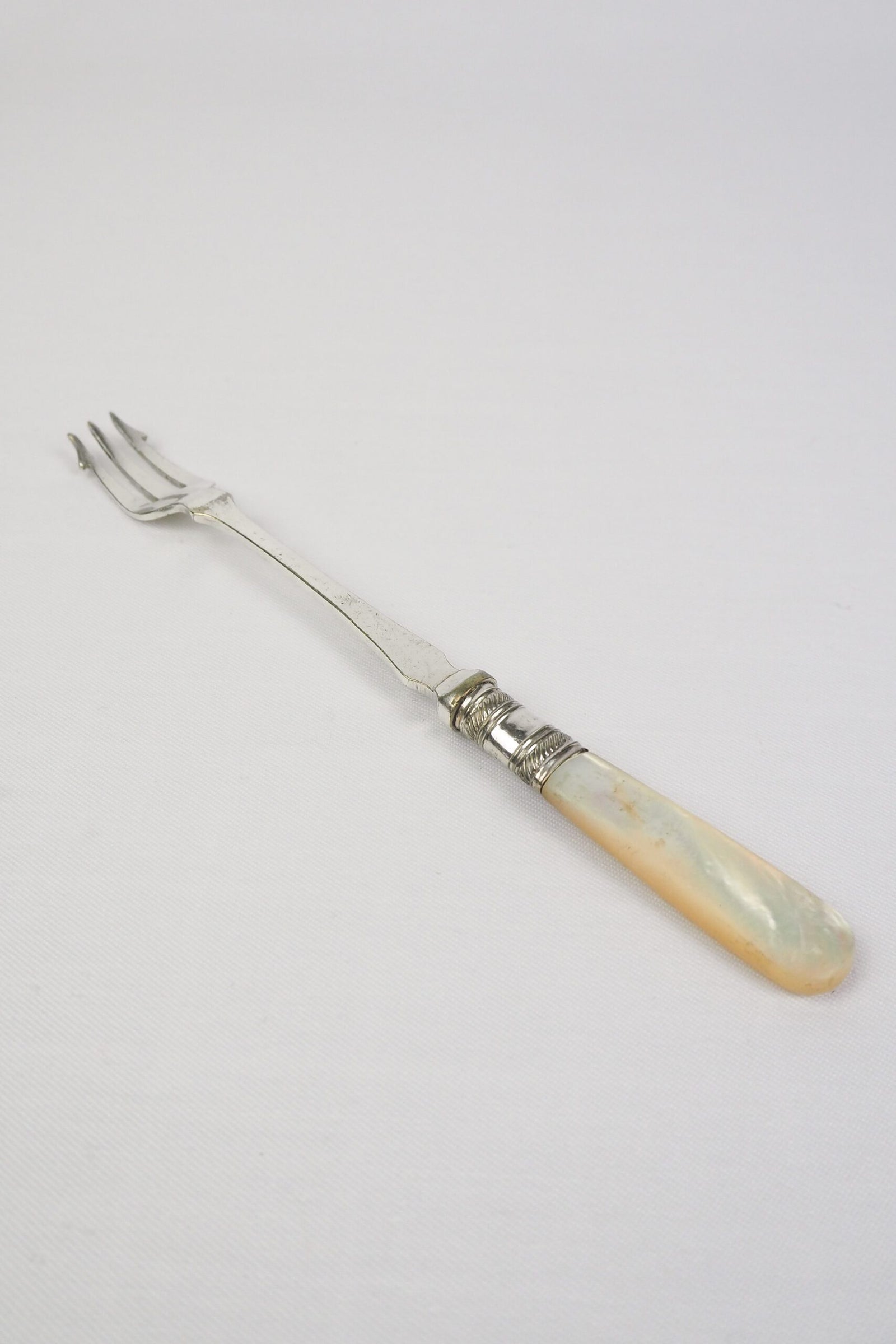 This Antique Pickle Fork is the perfect piece for your kitchen. With a beautiful Mother of Pearl handle and a Silver Plated neck and barbed prongs. Wildmore