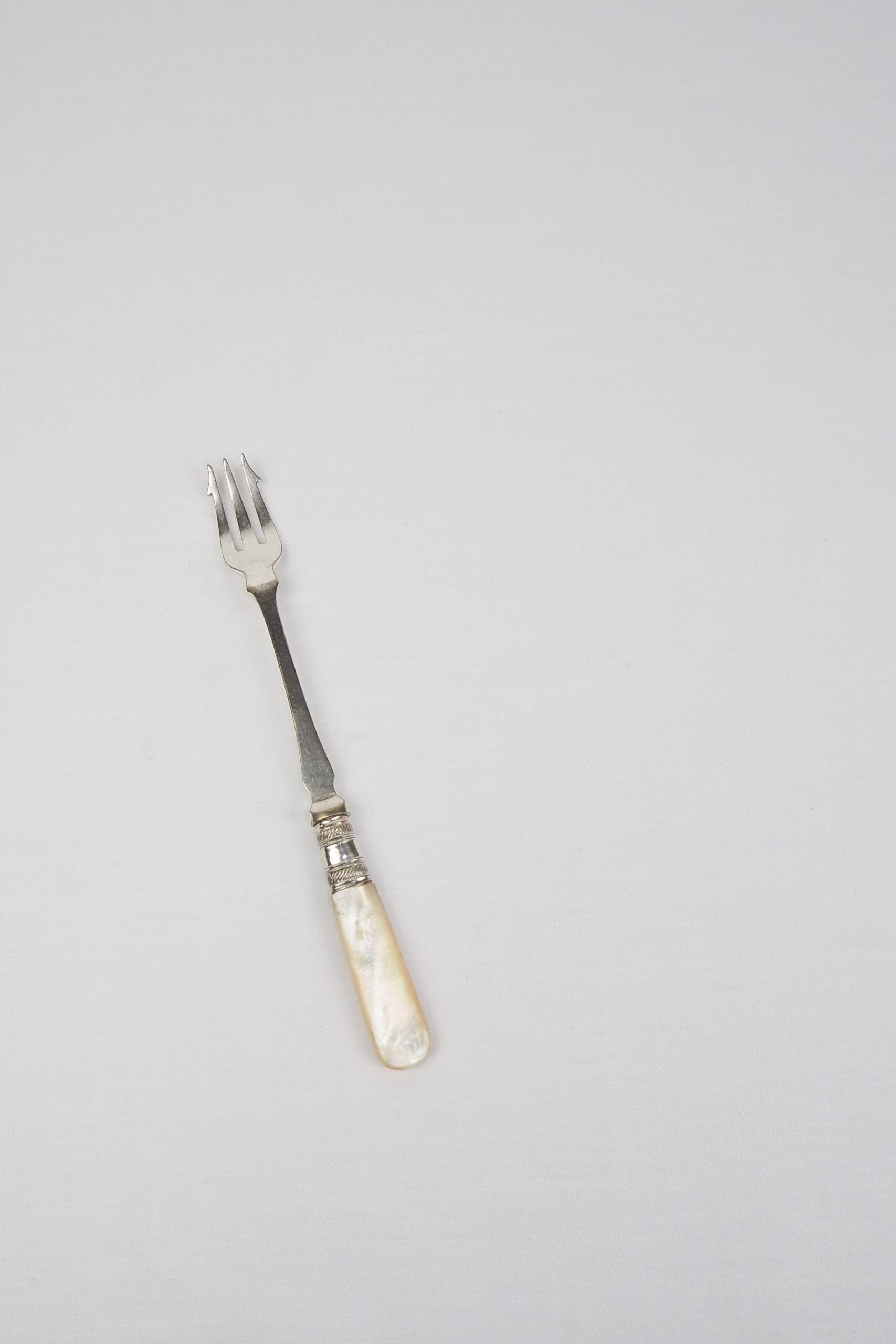 This Antique Pickle Fork is the perfect piece for your kitchen. With a beautiful Mother of Pearl handle and a Silver Plated neck and barbed prongs. Wildmore