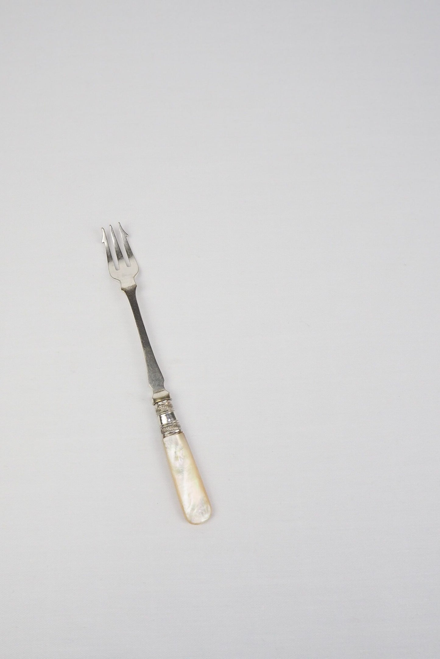This Antique Pickle Fork is the perfect piece for your kitchen. With a beautiful Mother of Pearl handle and a Silver Plated neck and barbed prongs. Wildmore