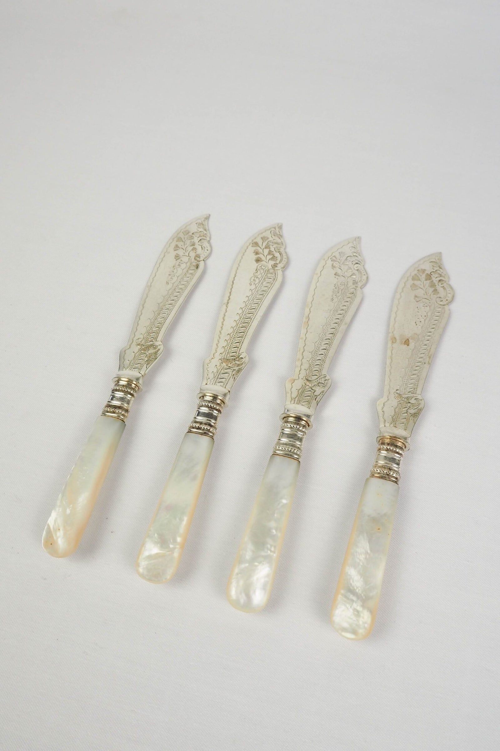 A Set of 4 Antique Silver Plate Fish Knives with mother of pearl handles. The blade of each Victorian Fish Knife has a beautifully etched floral pattern. Wildmore